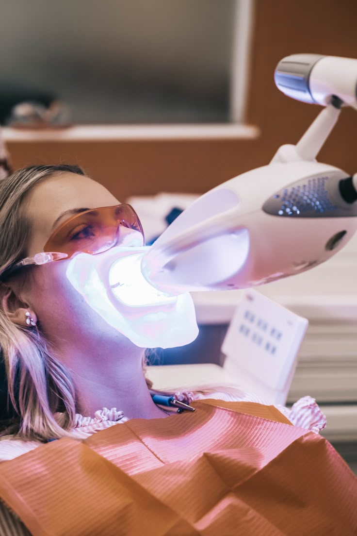 Paciente em sessão de clareamento dental com luz de ativamento